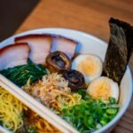 a bowl of food with chopsticks on a table